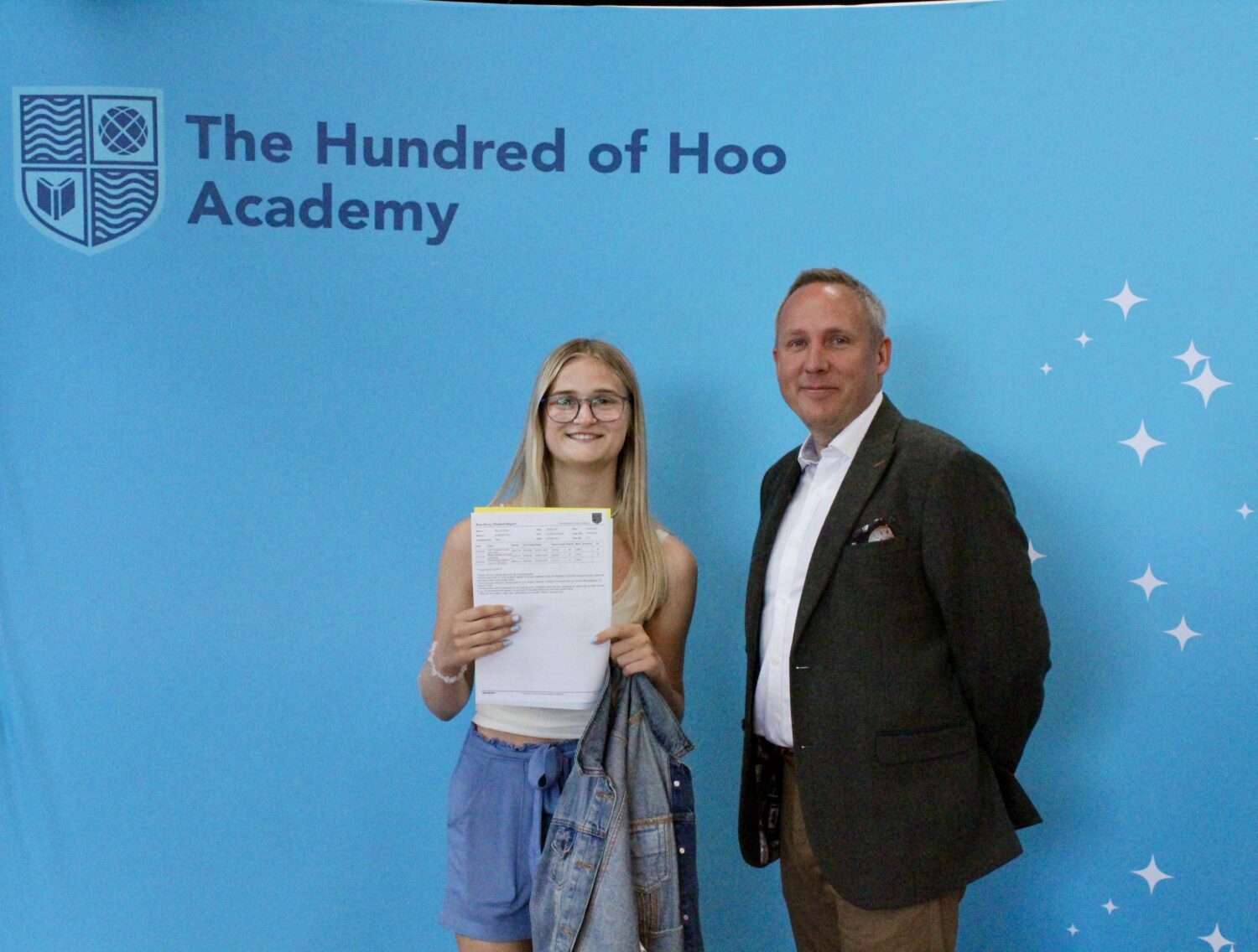 A female Post-16 student is pictured smiling for the camera alongside her Principal, after having just opened her A-Level results.